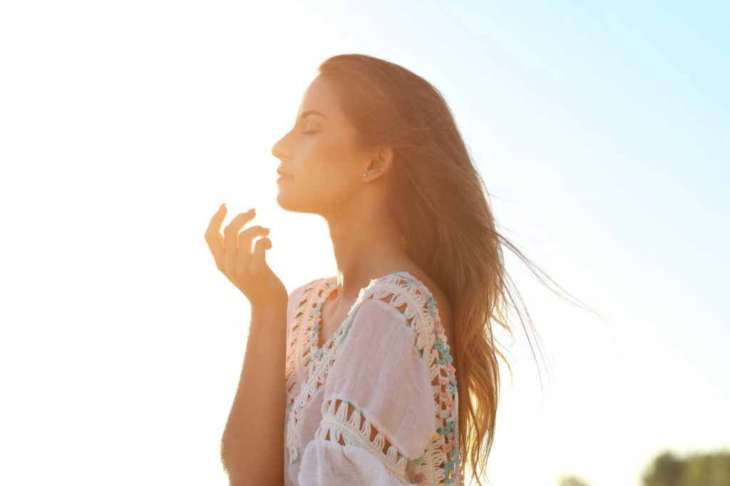 Woman practices breathing exercises outdoors in sunlight, enjoying spa-like relaxation at Just Breathe by Jodi, Cave Creek, AZ.